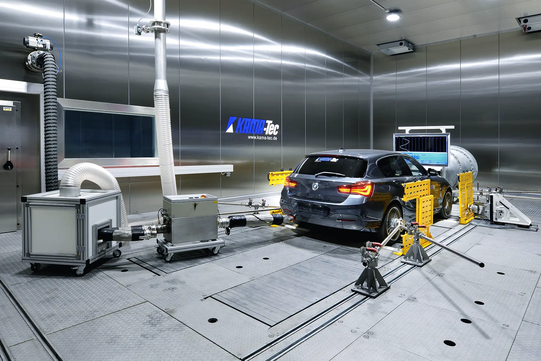 Pkw bei der Abgasprüfung auf einem klimatisierten Allrad-Rollenprüfstand mit Emissionsmesstechnik