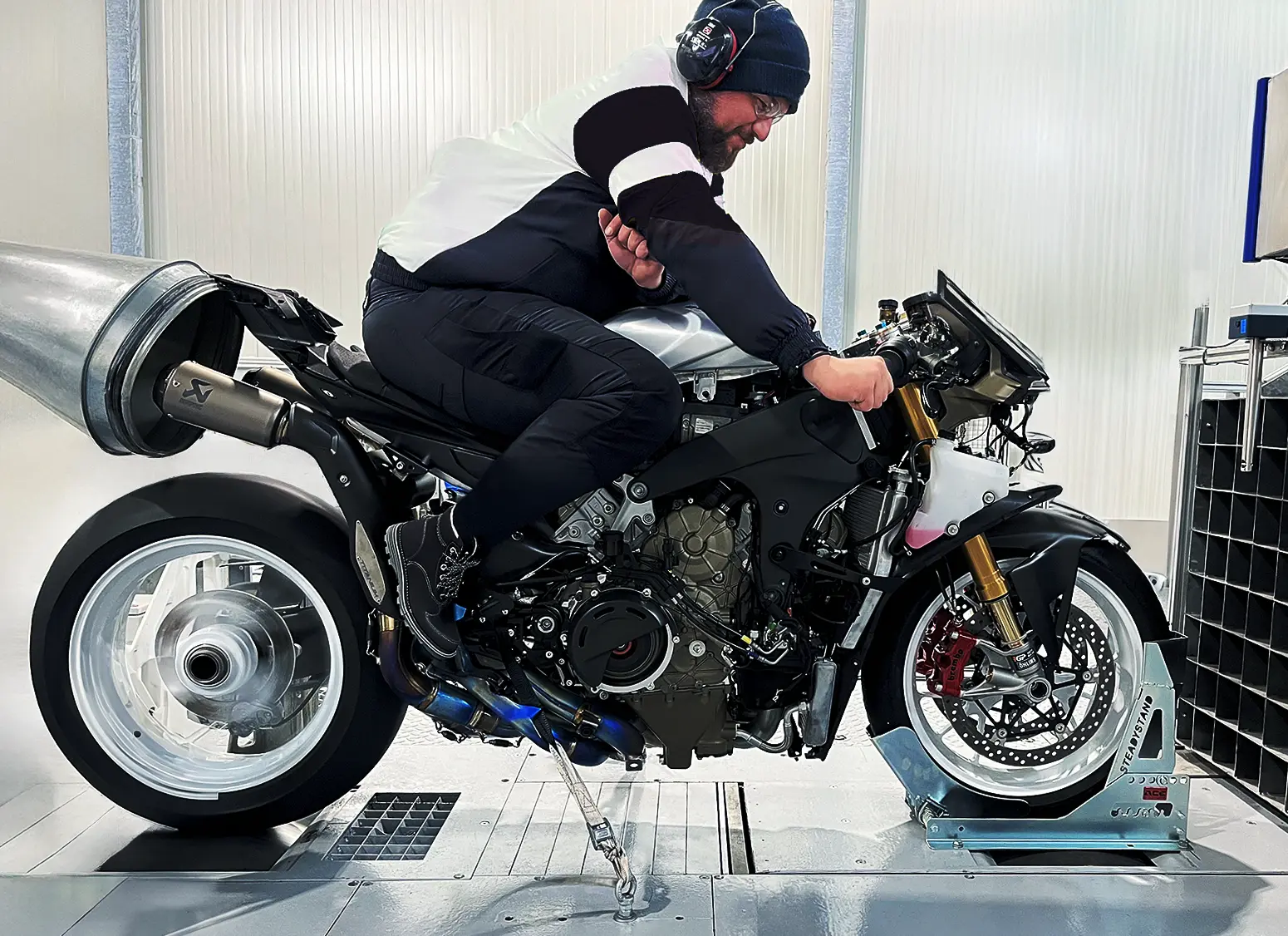 Mann auf Supersport Motorrad auf einem Allrad Rollenprüfstand während der Funktionserprobung