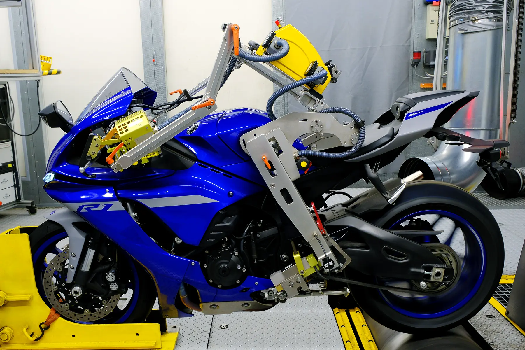Motorrad auf einem Abgas- und Applikationsprüfstand während der Dauerlauferprobung mit einem Fahrroboter